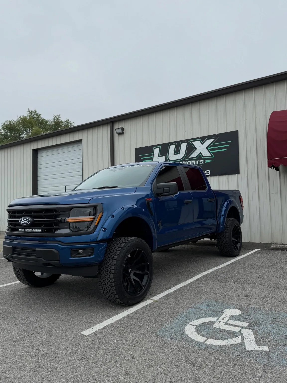Blue Ford truck outside the shop
