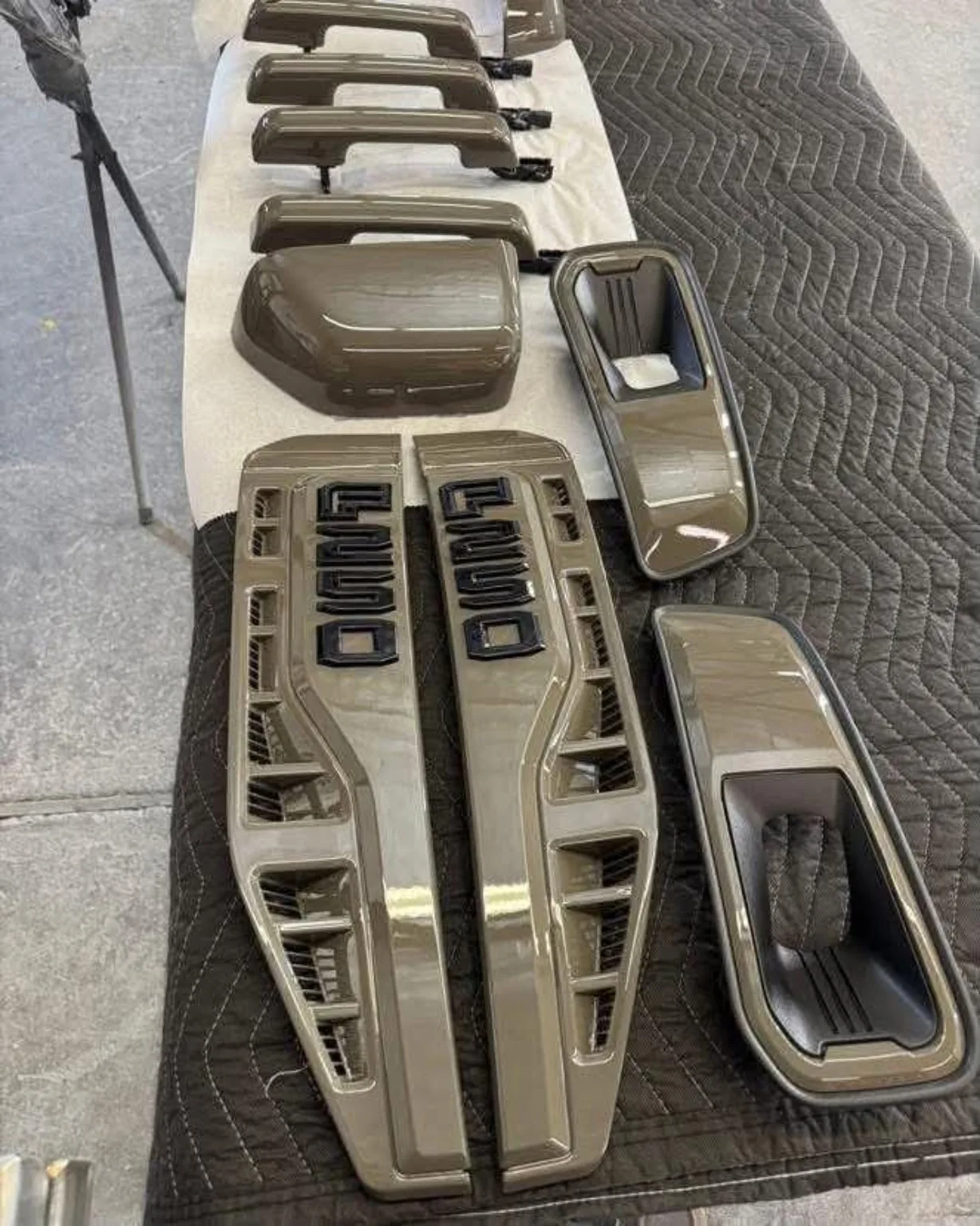 Custom-painted automotive trim parts laid out for assembly