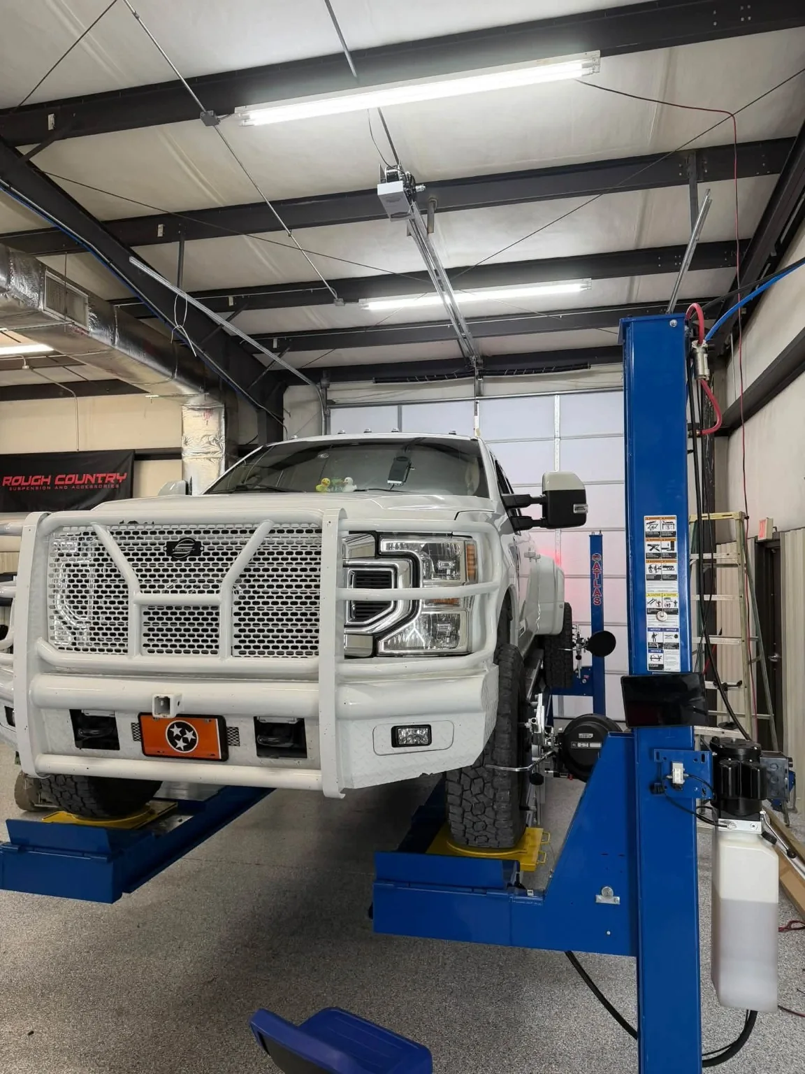 White heavy-duty truck positioned on the alignment rack
